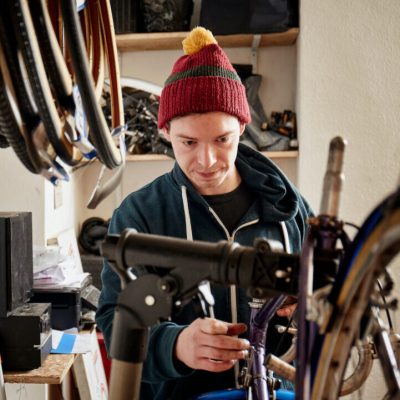 a-young-man-working-in-a-cycle-shop-repairing-a-b-2022-03-04-02-20-22-utc
